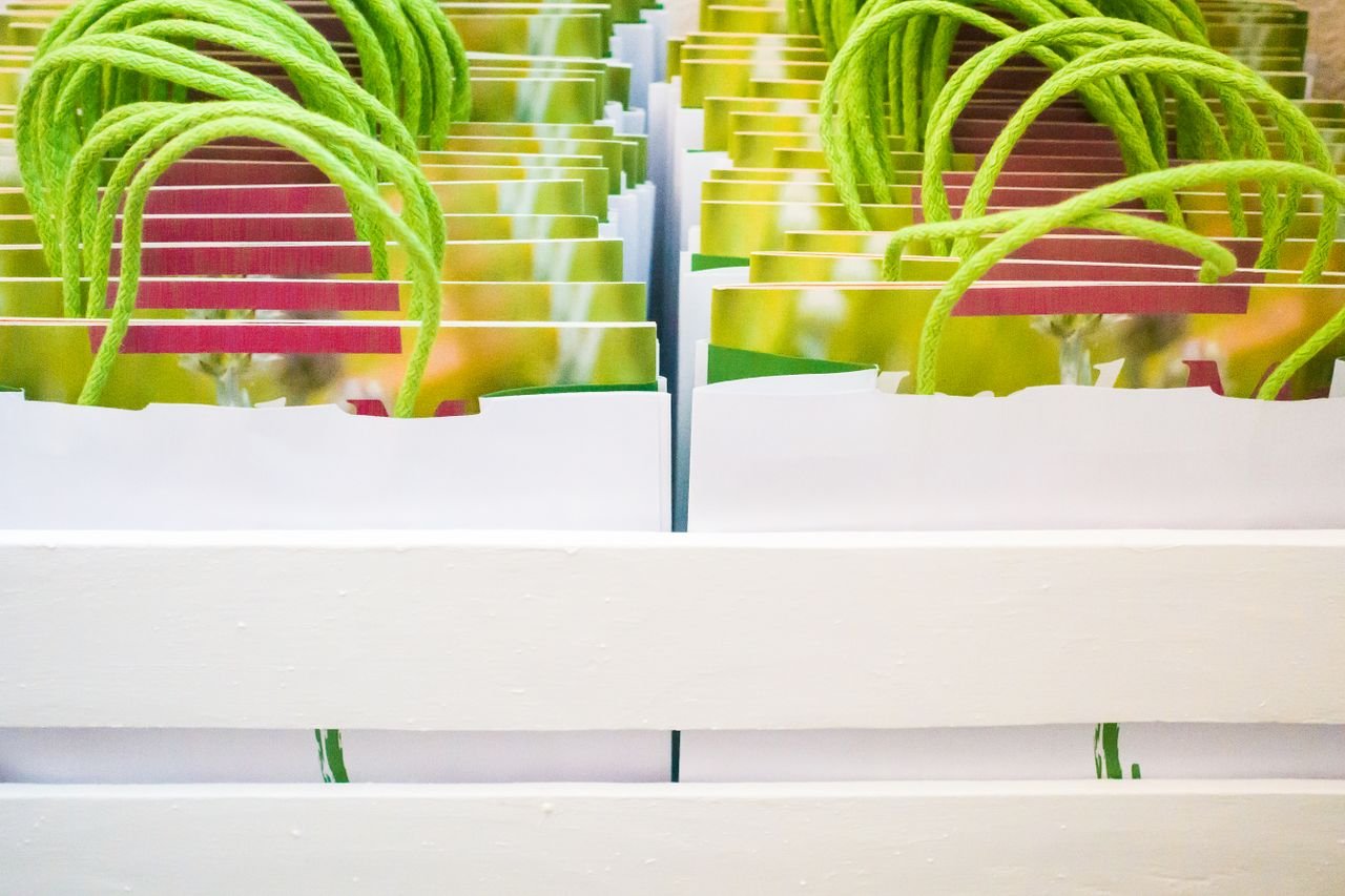 Crafting Captivating Headlines: Your awesome post title goes here Vibrant paper gift bags with green rope handles in a crate.